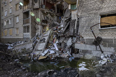 The interior contents of five floors of a residential apartment block, that was hit by a Russian missile strike on the 19 May 2022, spills out onto the street. Six people were rescued from the rubble...