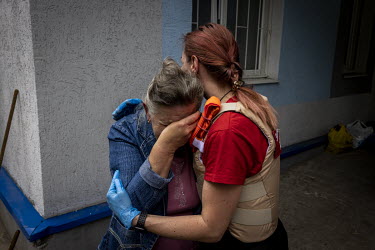 Valentyna is comforted by a medic as her brother, Oleksandr Evtushenko, was being evacuated from a hospital in Sloviansk.