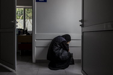 Ioanna, a nun from Sviatohirsk monastery, who was injured the day before by Russian shelling, crouches down to pray in the corridor of a hospital in Sloviansk as she waits at a hospital in Sloviansk a...