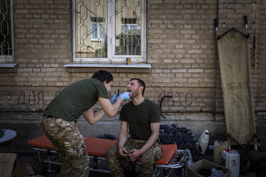 A Ukrainian soldier is examined for injuries and ailments at an aid station in the city of Bakhmut. After 100 days of war, and the fighting becoming increasingly brutal on the frontlines, medics talk...