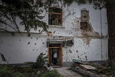 A monk in the doorway of a badly damaged building within the Sviatohirsk monastery complex. Russian artillery was landing nearby every 2-3 minutes and multiple buildings within the monastery were dama...