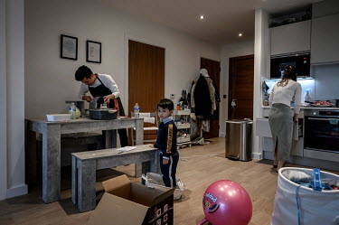 Valen Liu, his wife Kago Ng and their son Kasper prepare to eat a traditional Hong Kong hotpot, which they make regularly in their apartment in Sienna House where they are living after moving to the U...