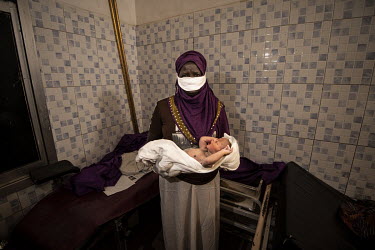 A midwife holds a newborn boy (4kg), delivered by emergency caesarean section to Safa Obur at the Military Hospital.  Since the end of 2013, conflict has cost almost 400,000 lives and left six million...