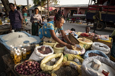A woman selects dried provisions from a stall in Ambovombe market, where food is plentiful yet many cannot afford to buy it.