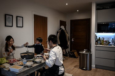Valen Liu, his wife Kago Ng and their son Kasper enjoy a traditional Hong Kong hotpot which they regularly enjoy in their apartment in Sienna House where they are living after moving to the UK on Brit...