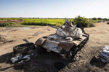 A destroyed tank lies on the banks of the Nile River.