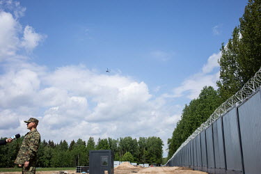 A border guard is interviewed by a televison journalist while he stands beside part of the newly built border wall erected between Poland and Belarus.  In the autumn of 2021 there were clashes between...