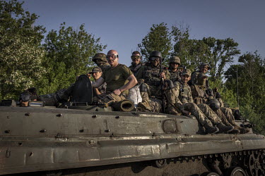 Ukrainian soldiers ride on top of an armoured fighting vehicle, somewhere between Pokrovsk and Kramatorsk, in the Donbas region.