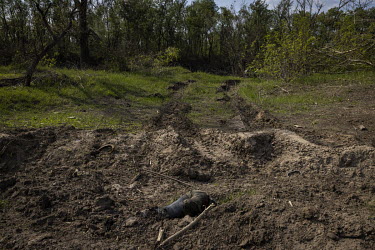 The half buried body of a Russian soldier lies in the dirt on the banks of the Seversky Donets river, at the scene of a failed Russian pontoon bridge crossing. Earlier in May 2022, Ukrainian forces ha...