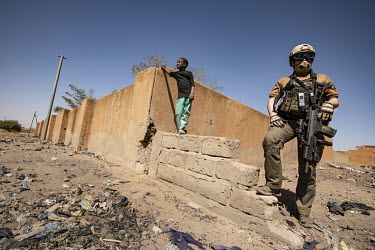 A boy stands on a wall beside an UN security officer who is supporting a MINUSMA operation in Gao.  In 2012, Islamist radicals linked to al-Qaeda, hijacked an uprising by ethnic Tuareg people and went...