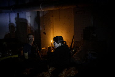 Civilians who have remained in the city living in the candle lit basement of an apartment block in Lysychansk.