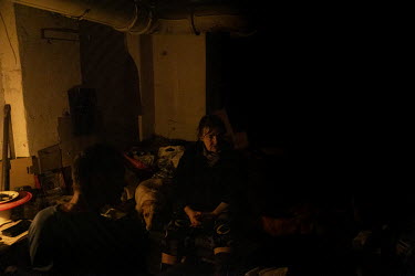Civilians who have remained in the city living in the candle lit basement of an apartment block in Lysychansk.