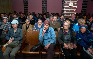 People attending a mass run by the Christian Church of Awakening in the Rubin Theatre. After the service people will receive a package of food. The population of Avdiivka before Russia's invasion was...