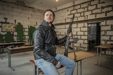 Professional opera singer Andrii Kharlamov, one of a group of community volunteers undergoing weapons training in a makeshift training camp hidden in a tower block.