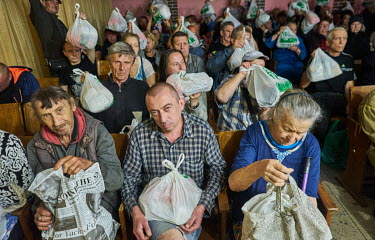 Residents with food packages distributed after a service by the Christian Church of Awakening at the Rubin Theatre. The population of Avdiivka before Russia's invasion was around 20,000, now just 3,00...