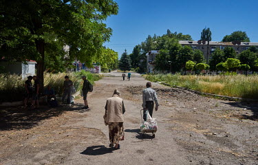 The elderly people of Avdiivka carry home plastic bags with humanitarian aid brought by the Christian Church of Awakening. The population of Avdiivka before Russia's invasion was around 20,000, now ju...