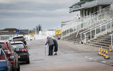 A couple head back to their car at the mass vaccination centre established at Epsom Racecourse after having COVID-19 vaccinations.