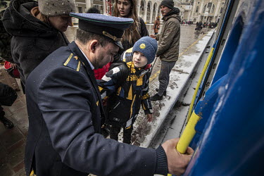 A train guard helps a family of refugees from Mykolayiv board a train at Odessa's railway staton, bound for Lviv.