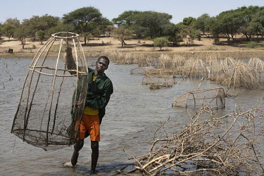 A fisherman carries an empty fish trap from waters in a part of Lake Chad where fishing has become almost unsustainable.  Lake Chad, which spanned 9,652sqm in 1963, has shrunk by 90 per cent in recent...