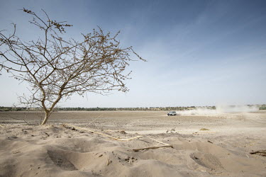 An NGO vehicle drives across the dustbowl on the bed of Lake Chad.  Lake Chad, which spanned 9,652sqm in 1963, has shrunk by 90 per cent in recent decades. Climate change is to blame, with population...