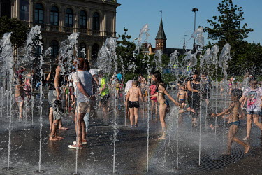 Kaliningraders flee the heat in a water fountain near the building of the former Koenigsberg Stock Exchange.