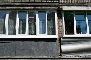 A Russian flag and the letter 'Z', which has become a symbol of support of Russia's military, on a window of a residential building.