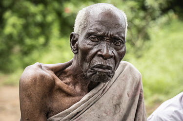 Duni Nzahi Mseche (89) sits in front of his shelter in Kaya Godhoma, a refuge built on holy ground near the remote village of Mrima wa Ndege, provides sanctuary to those accused of witchcraft.  Two ye...