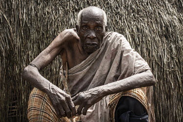 Duni Nzahi Mseche (89) sits in front of his shelter in Kaya Godhoma, a refuge built on holy ground near the remote village of Mrima wa Ndege, provides sanctuary to those accused of witchcraft.  Two ye...
