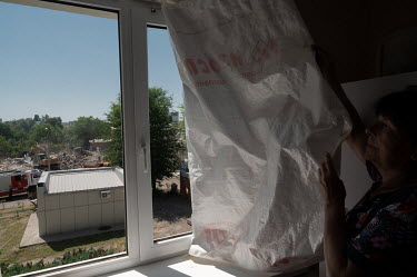 A woman checks the new windows in her apartment. The residential building, at the intersection of Popov and Mayakovsky streets, had its windows blown out during an explosion on the night of 3 July 202...