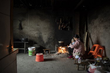 Xie Xianmei holds her son in the home of her adoptive family in Baijie township. Xie was a second child of parents from the rural province of Sichuan who were forced into adoption because of the stric...