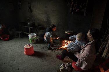 Xie Xianmei holds her son in the home of her adoptive family in Baijie township. Xie was a second child of parents from the rural province of Sichuan who were forced into adoption because of the stric...