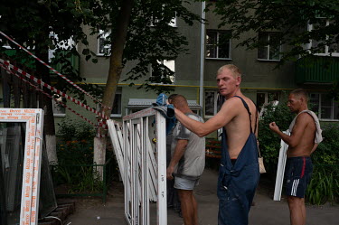 Municipal workers installing replacement windows in a residential building, at the intersection of Popov and Mayakovsky streets, that had its windows blown out during an explosion on the night of 3 Ju...