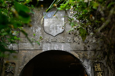 Cold War-era slogans and a shield celebrating US-ROC military cooperation above the entrance to an abandoned air raid shelter in Zhuluo village. Nangan is the main island in the Matsu archipelago, a f...