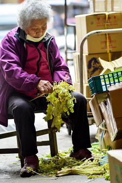 A woman prepares vegetables for sale in a back alley market on Nangan, the main island in the Matsu archipelago, a frontline island group belonging to Taiwan that lies just a few miles off the mainlan...