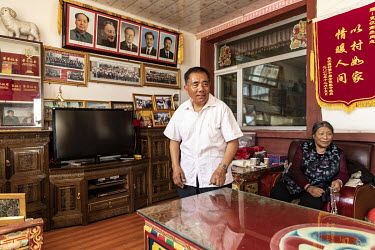 Pictures of former and current Chinese leaders hang on the wall of a home at a showcase Tibetan village.