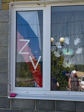 'V' and 'Z' symbols, denoting support for the Russian military, displayed in the window of a house.