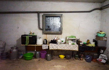 A makeshift kitchen in a cellar which is also used as a bomb shelter.