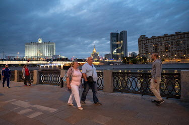 People walk along the embankment of the Moscow River. The letter 'Z', created by illuminating various offices in a government building, shine from a building on the far bank. 'Z' has become a pro-Puti...