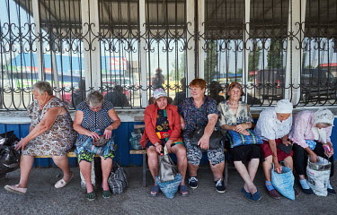 Pensioners wait at the bus stop near the market In Kurakhovo.