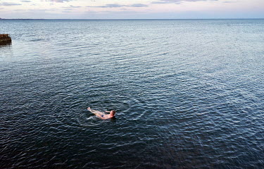 A man swims in the Black Sea despite the ban on swimming due to sea mines.