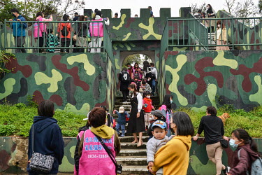 Domestic Taiwanese tourists, part of a junior school tour, clamber over the entrance gateway to underground Stronghold No.77, one of a string of Cold War-era coastal military defences located along th...
