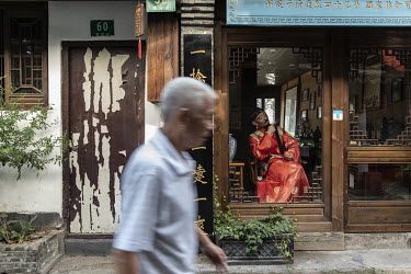 A man walks past an antiques shop in the Zhujiajiao Water Town in Shanghai. Zhujiajiao is one of several canal based towns in the Yangtze Delta region that many tourists visit.