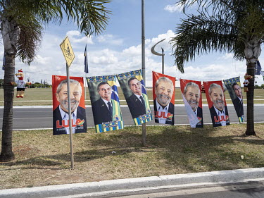 A street vendor sells flags featuring the two presidential candidates Jair Messias Bolsonaro and Lula da Silva. The monument in the background is the JK Memorial, dedicated to Juscelino Kubitschek, fo...
