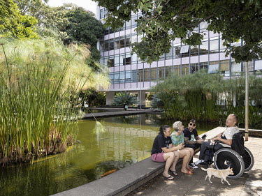 People resting beside an artificial water feature in the southern residential wing of a 'superquadra'. Each wing is divided up into 'superquadras', consisting of 20 apartment buildings and a main road...
