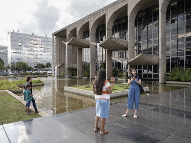 A woman is praying in front of the Palace of Justice, designed by Oscar Niemeyer, at the Square of the Three Powers.