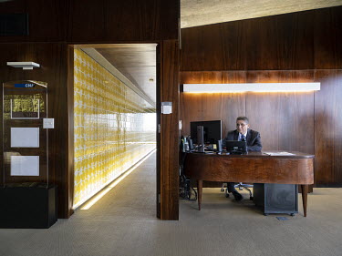 The concierge in the office building Edificio Camargo Correa in the Southern Commercial Sector. The corridor of tiles is a work of art by Athos Bulcao.