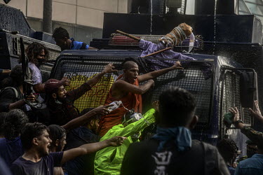 Protestors climb onto police wagons during a march on Colombo's fort area on Thursday 19th May.