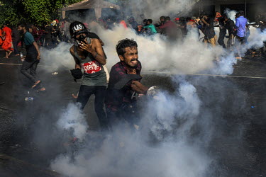 Protestors flee tear gas during a protest in Colombo's fort area on 19th May.