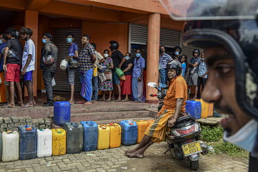 People queue with containers for fuel as shortages worsen during Sri Lanka's economic crisis.