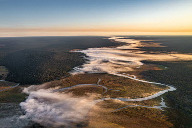 Fog rises off the Cuito river in the early morning.